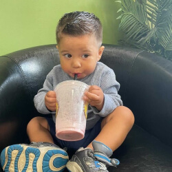 Baby having fun drinking his healthy fruit shakes.