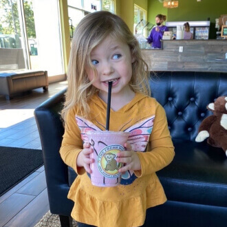 a cute girl at the Fresh Monkee store drinking a kids special shake